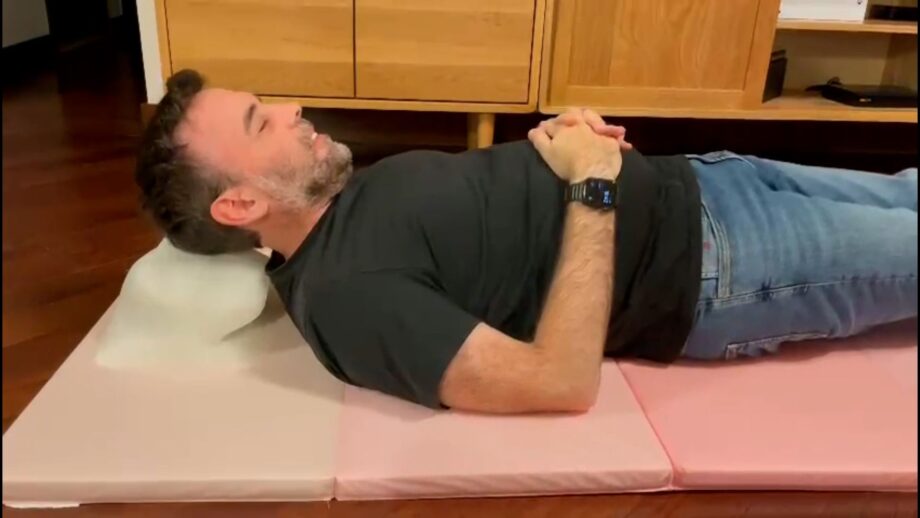 A person lying on the floor using an AI powered headrest.