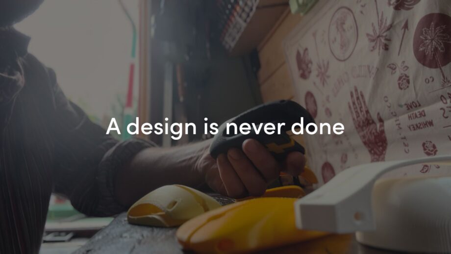 Multiple 3D printed iterations of DRAG - an assistive writing device. The title 'A design is never done' overlaid in white text.