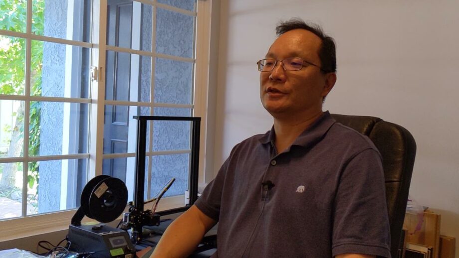 Andy Lin sat next to a 3D printer.