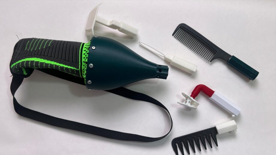 A 3d printed arm attachment with various modules on a table.