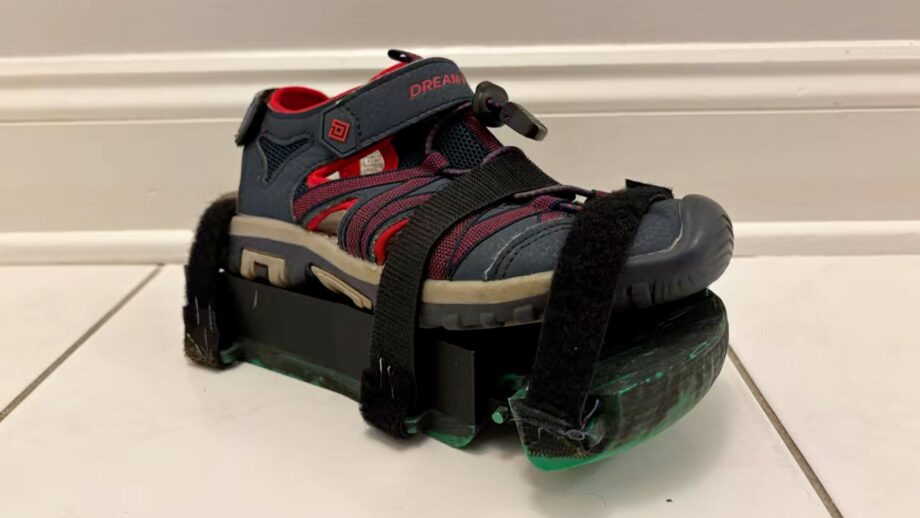 A 3D printed sandal attachment with a raised lateral platform, designed to Velcro onto a shoe and support improved posture for a young athlete.