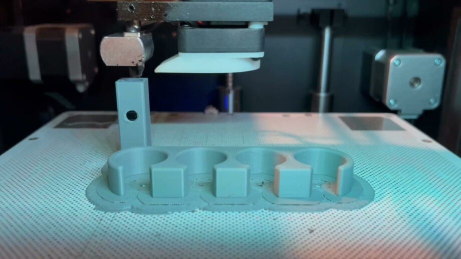 A 3D print bed with an assistive writing device on it.