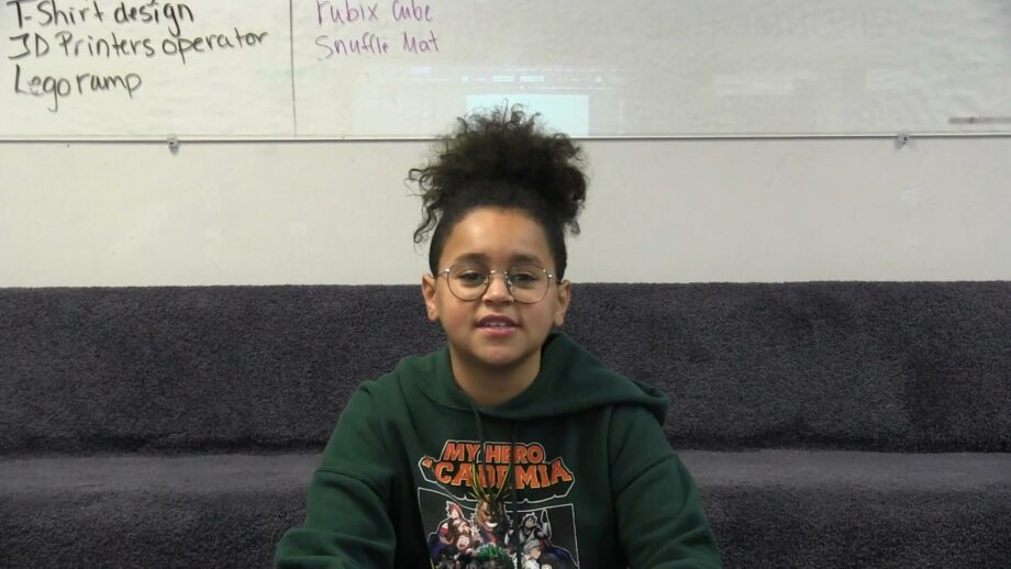 A young student sat on a sofa looking at the camera.
