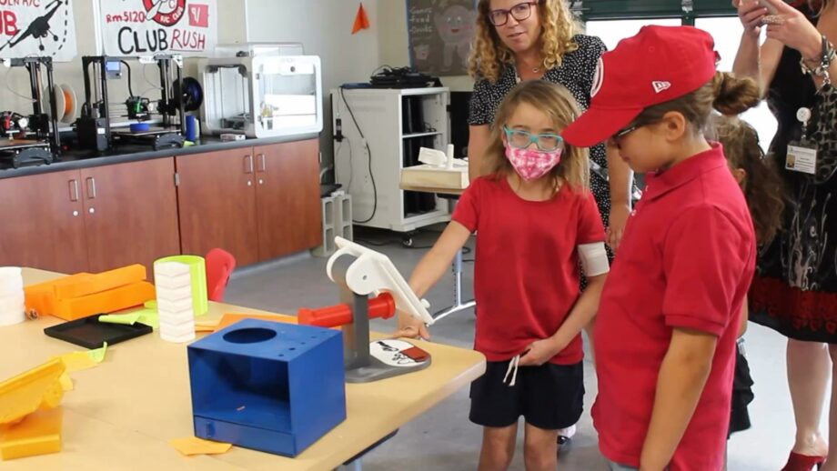 A young student looking at a 3D printed iPad stand.