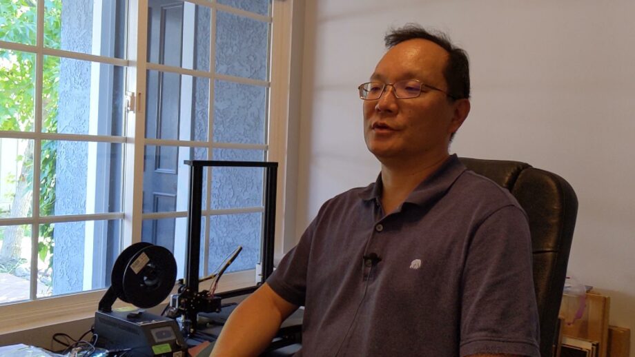 Andy Lin sat next to a 3D printer.