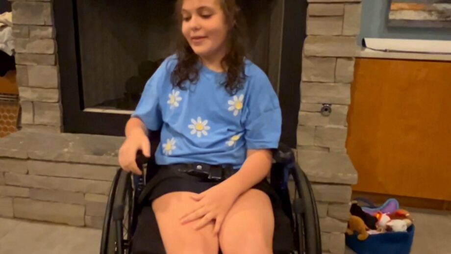 A young girl sitting in a wheelchair.