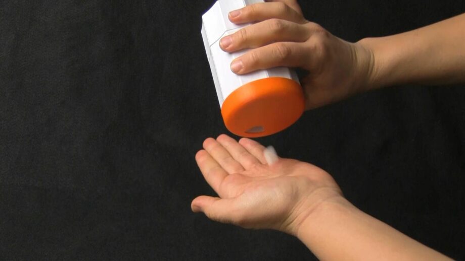 A person using a 3d printed pill dispenser that dispenses one pill at a time.