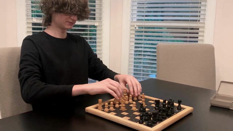 A student simulating playing chess by using a blindfold.