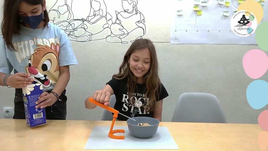 A student using an assistive cutlery device that holds a spoon.