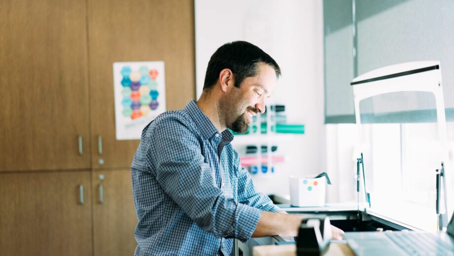 Matt Zigler, teacher at Bullis School, attending to a 3D printer.
