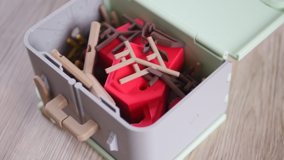 Pinchee's suitcase gameboard half folded up showing loose components inside.