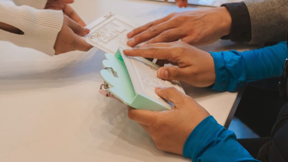 A person with visual impairment runs their fingers over a raised tactile map designed to help visitors navigate the La Nube STEAM Discovery Center.
