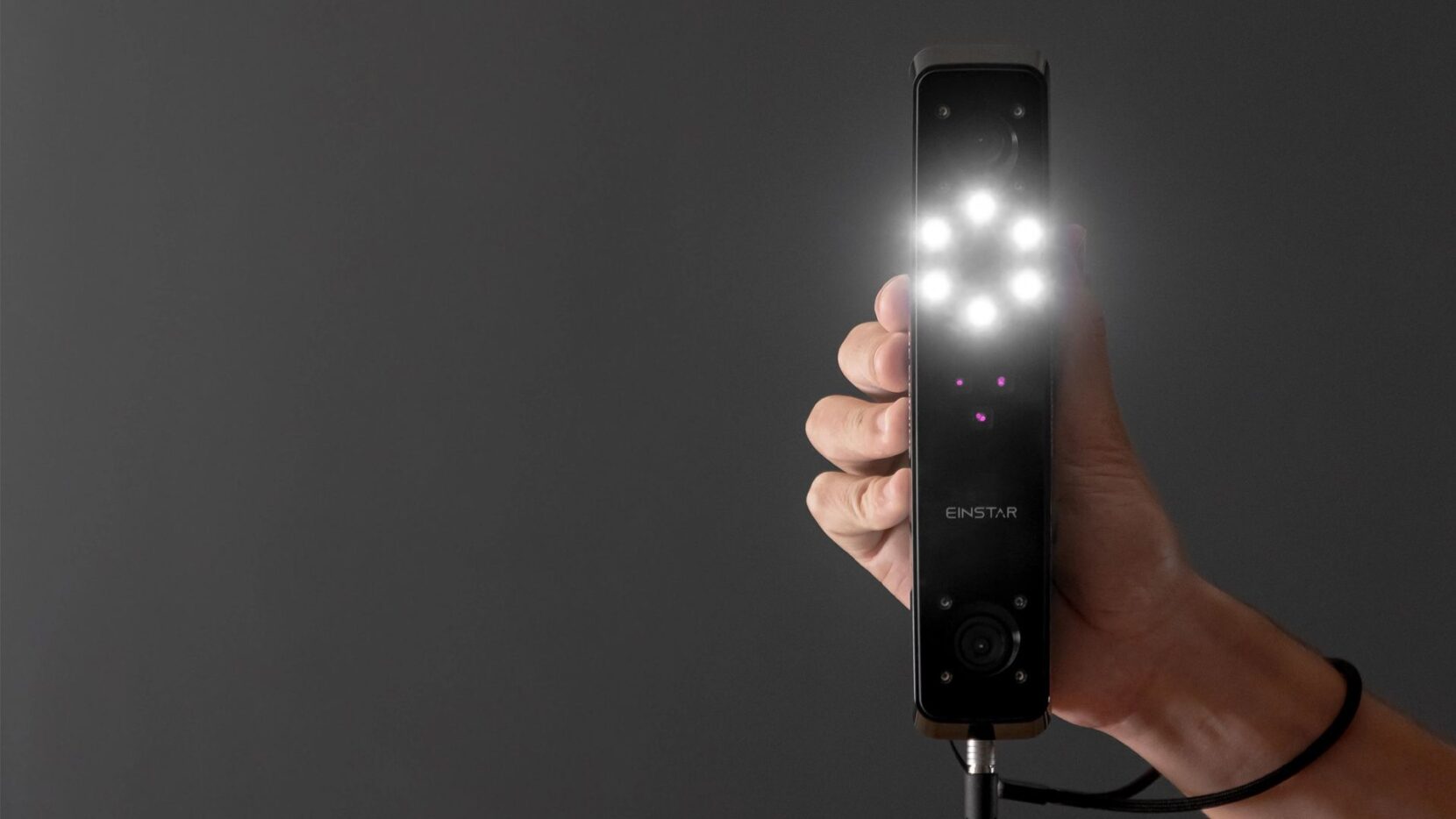 A person holding the EINSTAR 3D scanner - pointing it in the direction of the camera.