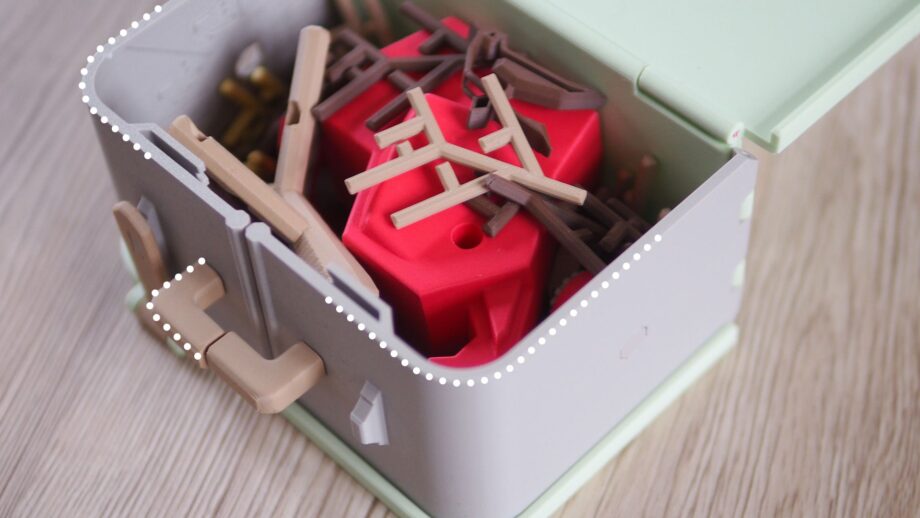 An image of the Pinchee game inside its suitcase-style case, with dotted white lines highlighting the rounded filleted edges that improve comfort and safety.